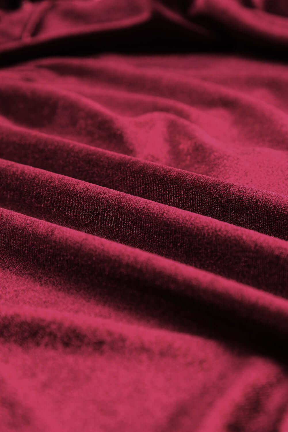 Close-up of luxurious burgundy velvet fabric, showcasing its soft texture and rich color for the SEQUIN SIREN Top.