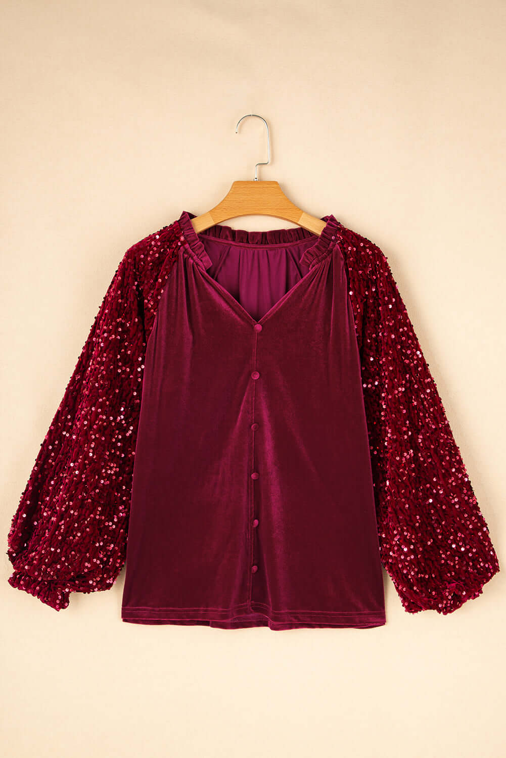 SEQUIN SIREN top featuring a v-cut neckline, ruffled details, and dazzling sequined sleeves in rich burgundy velvet.