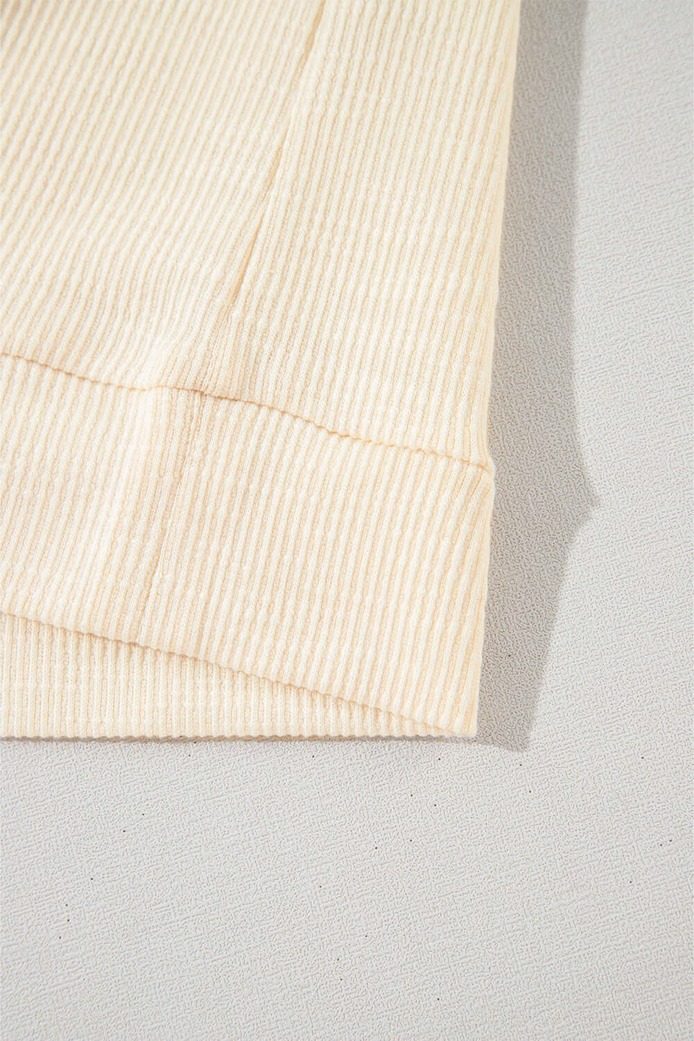 close-up of the ribbed fabric and banded bottom of the VANILLA SKYE TOP in a soft vanilla shade.