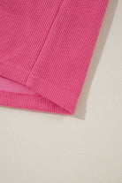 Close-up of the ribbed hem of the Petal Perfection knit top in vibrant pink, showcasing its quality fabric texture.