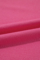 Close-up of pink ribbed knit fabric showcasing its texture and softness, ideal for stylish clothing like tops.