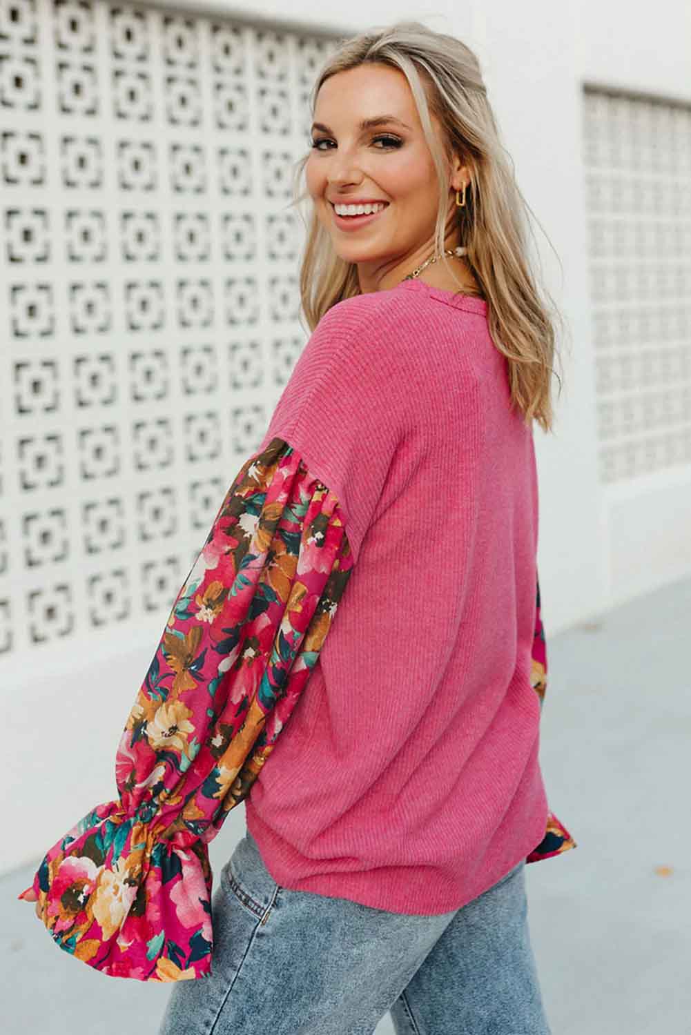 Stylish woman in Petal Perfection knit top with floral ruffled sleeves, showcasing a chic patchwork design and casual vibe.