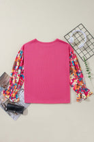 Back view of Petal Perfection top with pink body and colorful ruffled sleeves, showcasing its chic patchwork design.