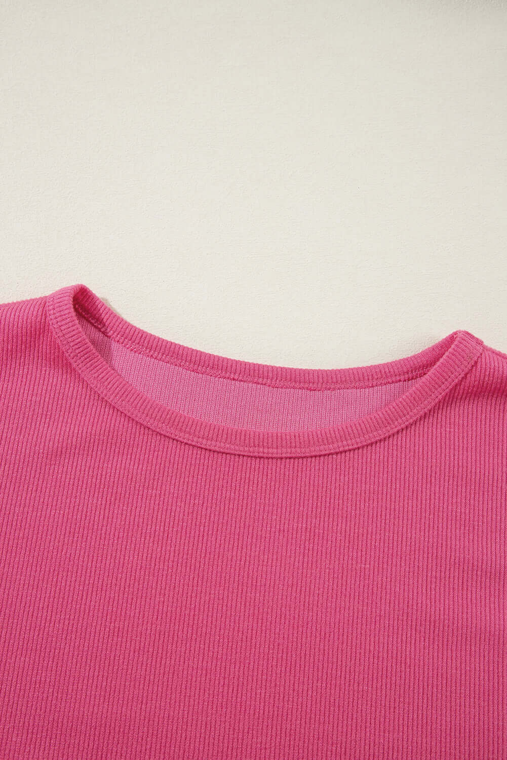 Close-up of the Petal Perfection knit top in vibrant pink, showcasing the ribbed texture and round neckline.