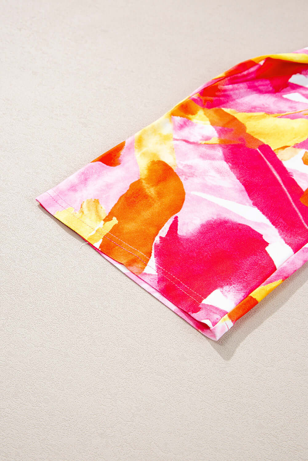 Close-up of SUNKISSED BABE TOP featuring vibrant brush stroke design in pink and yellow hues, highlighting the playful style.