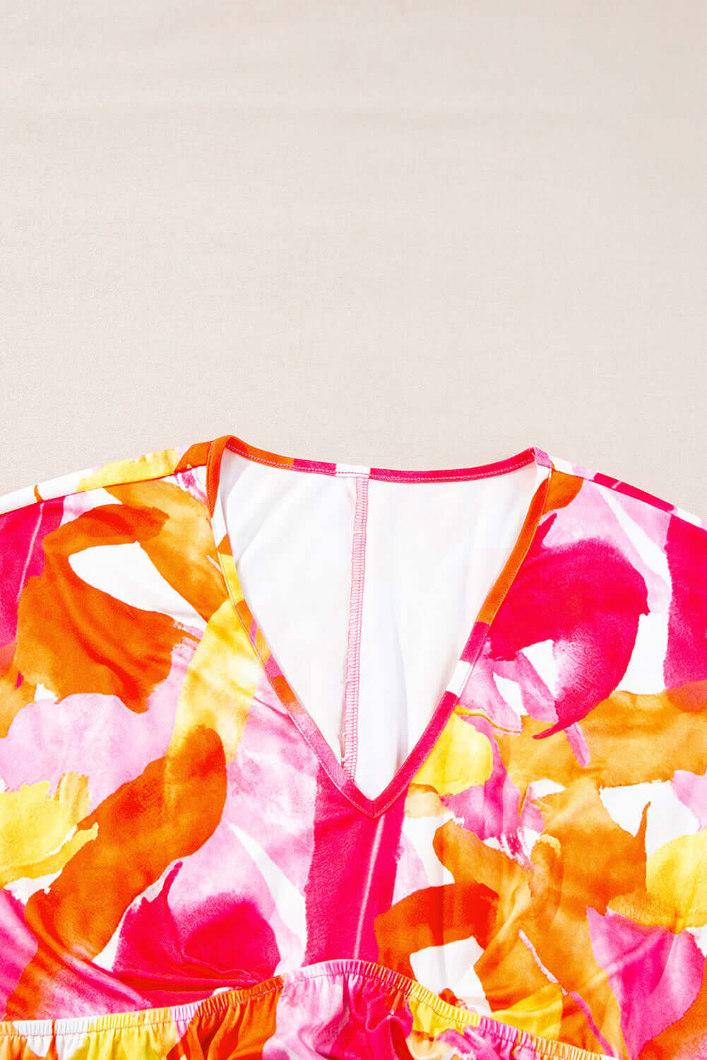 Vibrant SUNKISSED BABE TOP featuring colorful brush strokes, v-neckline, and playful babydoll cut on a light background.