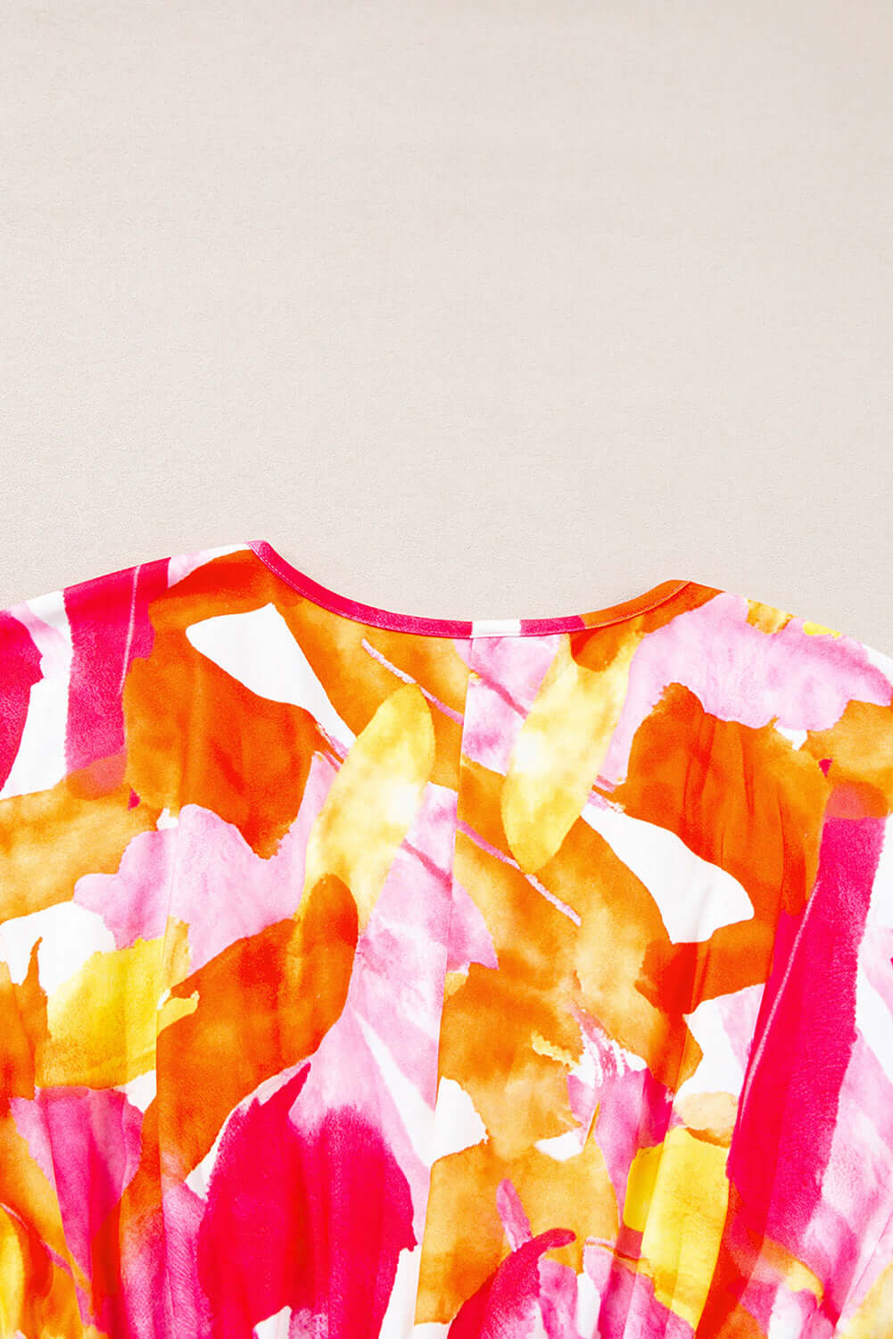 SUNKISSED BABE TOP with vibrant brush stroke design in pink and orange, showcasing a charming v-neck and 3/4 sleeves.