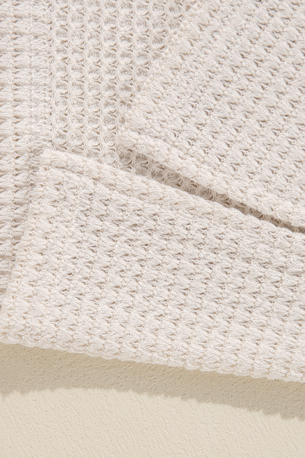 Close-up of soft vanilla waffle knit fabric of the Finally Made It top, showcasing its unique textured design and stretchy material.