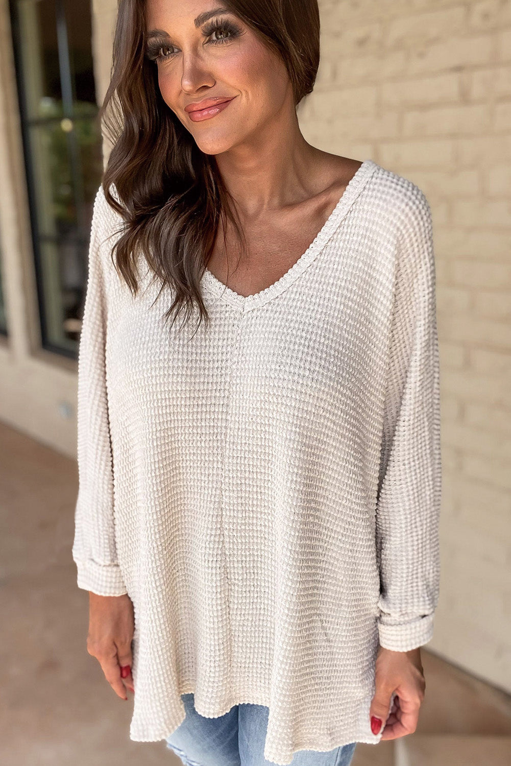 Woman wearing luxurious Finally Made It top in soft, stretchy waffle knit with a V-neckline and loose fit, perfect for casual elegance.