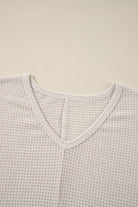 Luxurious waffle knit top in vanilla with V-neckline and loose fit design.