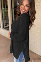 Black Finally Made It top featuring a soft waffle knit design, side slits, and a stylish V-neckline for a relaxed look.