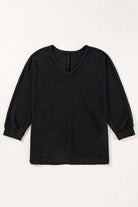 Black waffle knit Finally Made It top with V-neckline and loose fit, showcasing stylish side slits.