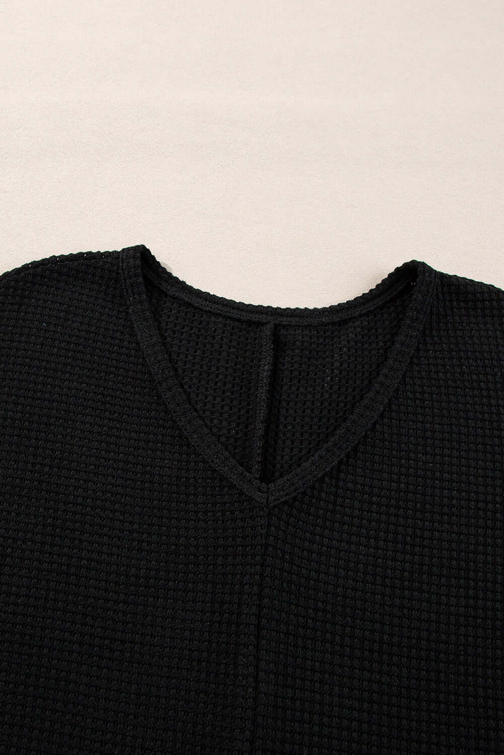 Close-up of the V-neckline and textured waffle knit of the black Finally Made It top, showcasing its luxurious design.