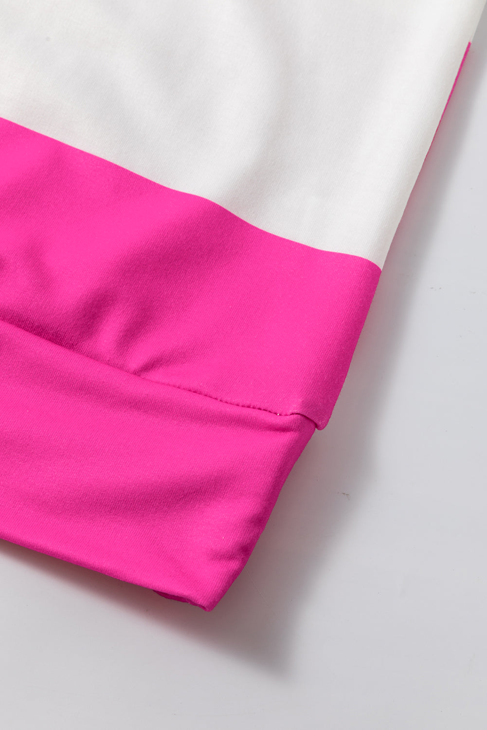 Close-up of fuchsia and white color block sleeve with a relaxed drop shoulder design on the Going My Way Top.