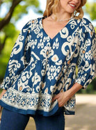 Vibrant cobalt blue boho chic V-neck blouse with white and peach accents, featuring a relaxed silhouette and tiered design.