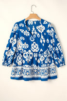 Boho chic V-neck blouse in vibrant cobalt blue with white and peach patterns, featuring a tiered design.