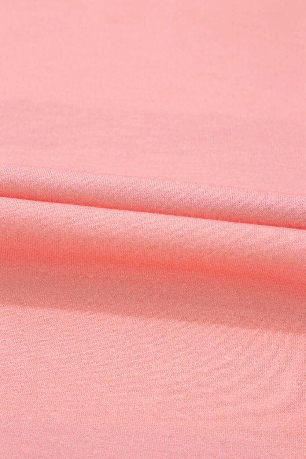 Pink fabric close-up showing smooth texture and soft material.