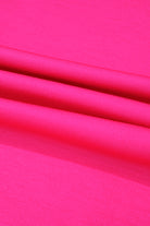 Bright pink fabric texture showcases vibrant polyester and elastane blend.