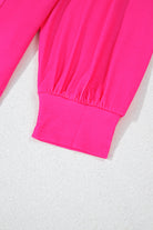 Vibrant pink drop shoulder sleeve detail on colorblock crew neck top with ribbed cuff.