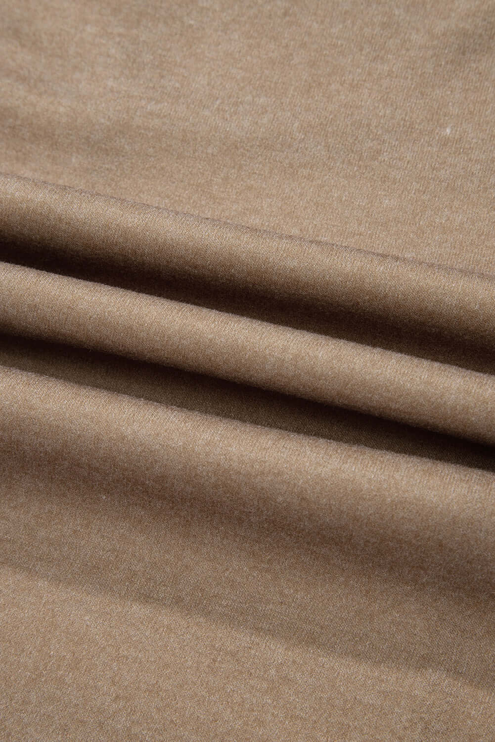 Close-up of brown textured fabric with soft folds and subtle sheen.