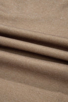 Close-up of brown textured fabric with soft folds and subtle sheen.