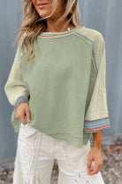 Stylish waffle knit t-shirt with raglan sleeves, contrast stripe stitching, and raw hem, perfect for a casual chic look.