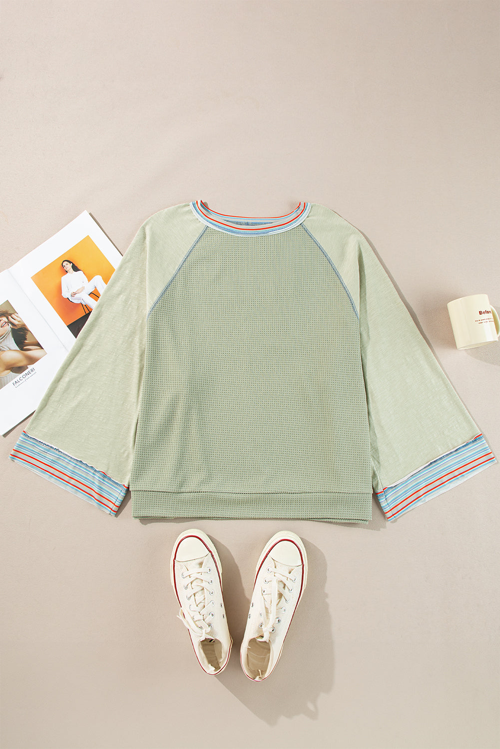 "Stylish waffle knit t-shirt with bracelet sleeves and contrast stitching laid flat with sneakers and magazine for a chic look"