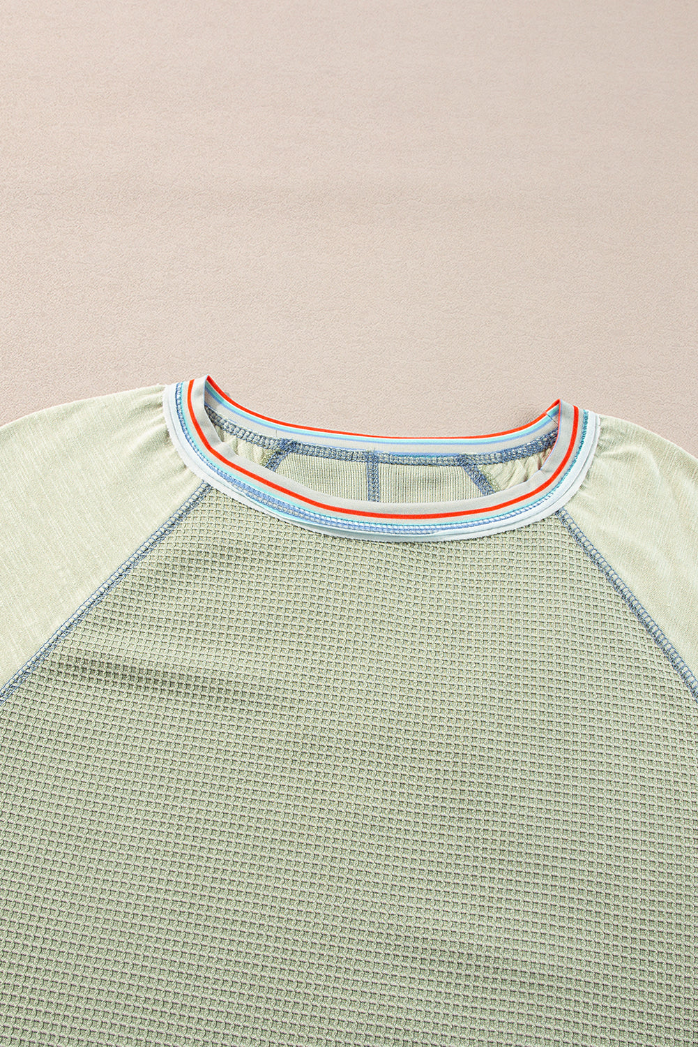 Waffle knit panel t-shirt with raglan sleeves and contrast stripe stitching, featuring a stylish raw hem finish.