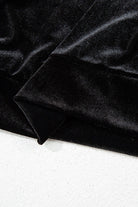 Close-up of soft black velvet fabric showcasing luxurious texture and sheen, ideal for elegant women's tops.