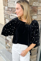 Elegant velvet women's top with pearl embellishments and half puff sleeves, perfect for special occasions and nights out.