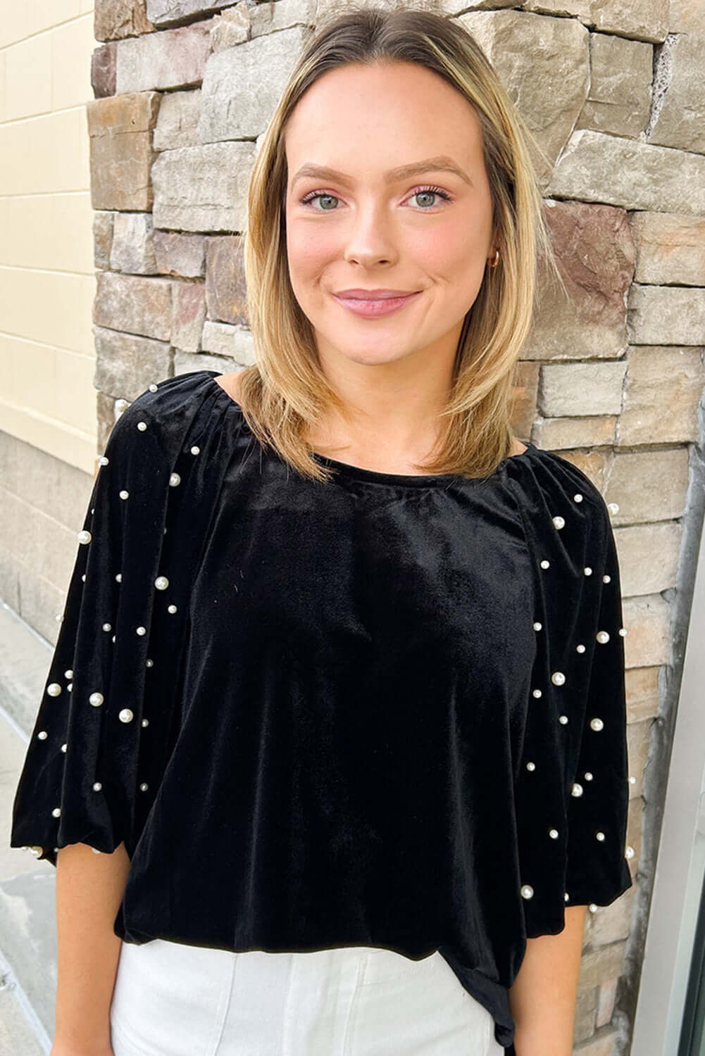 Elegant black velvet top with pearl embellishments and half puff sleeves, perfect for special occasions or a night out.