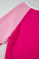 Close-up of the PROMISE YOU Top by Vivian-Lu featuring a vibrant pink body and striped raglan sleeves.