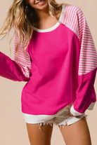 Model wearing the PROMISE YOU Top by Vivian-Lu in pink with striped sleeves, showcasing a sporty and stylish look.