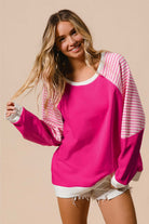 Woman wearing vibrant pink PROMISE YOU Top by Vivian-Lu with striped patchwork design and sporty sleeves.