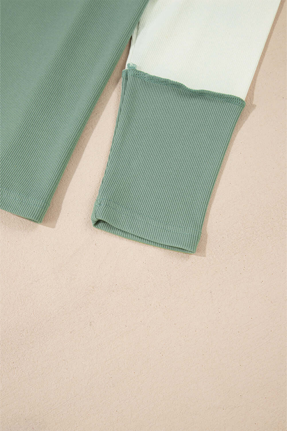 Close-up of the ribbed sleeves of the Whispering Willow top, showcasing the color block design and soft fabric texture.