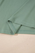 Close-up of ribbed detailing and hemline of the Whispering Willow top in soft green color.