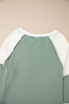 Back view of the Whispering Willow top showcasing the chic color block design and ribbed detailing.