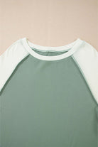 Whispering Willow top in green with contrasting light green sleeves, showcasing a stylish crew neck design.