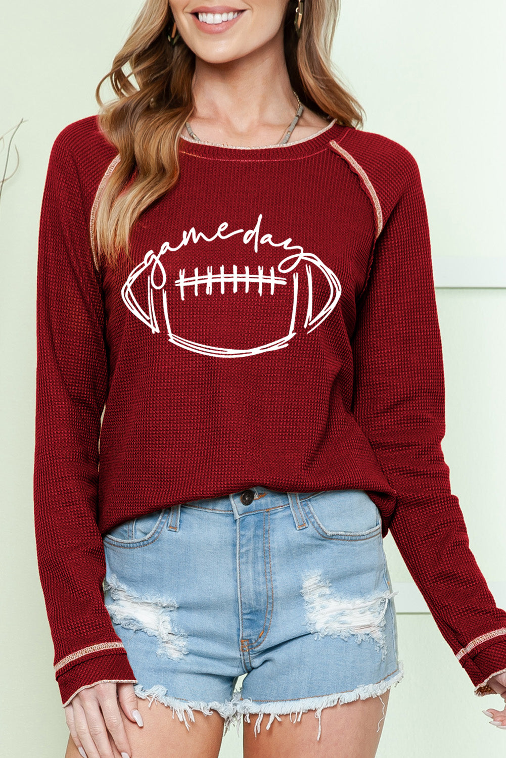 "KICKOFF TIME TOP with football design, raglan sleeves, and waffle knit fabric, styled with denim shorts for game day"