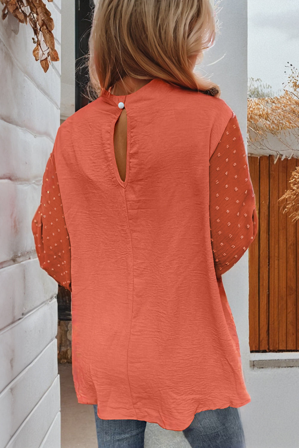 Rust-colored blouse with balloon sleeves and keyhole back detail, featuring Swiss dot pattern on sleeves and gold button closure.