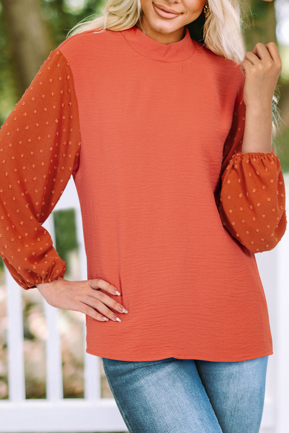 Woman wearing an Autumn Sunset Top in rust, featuring balloon sleeves with Swiss dot pattern and gold button keyhole detail.