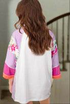 Back view of the Enchanted Aura Top showcasing colorful floral prints and chic color-block design.