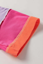 Close-up of the color-blocked sleeve of the Enchanted Aura Top in vibrant pink and orange hues.