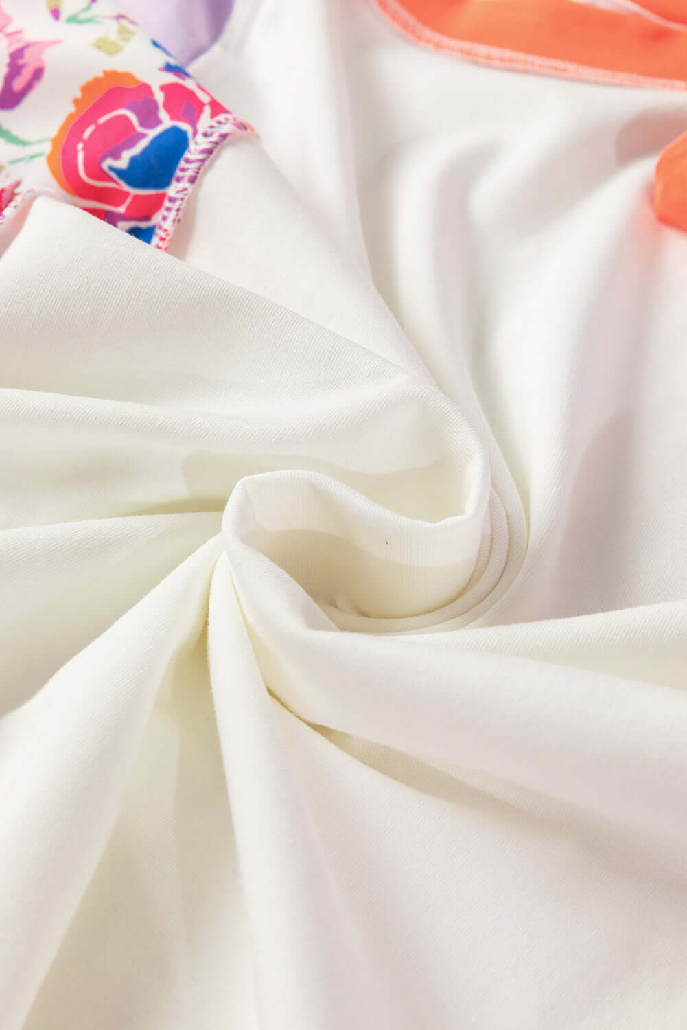 Close-up of the Enchanted Aura Top's soft fabric showcasing its floral print and color-block design.