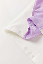 Close-up of the Enchanted Aura Top's color-block design featuring white and lavender fabrics.