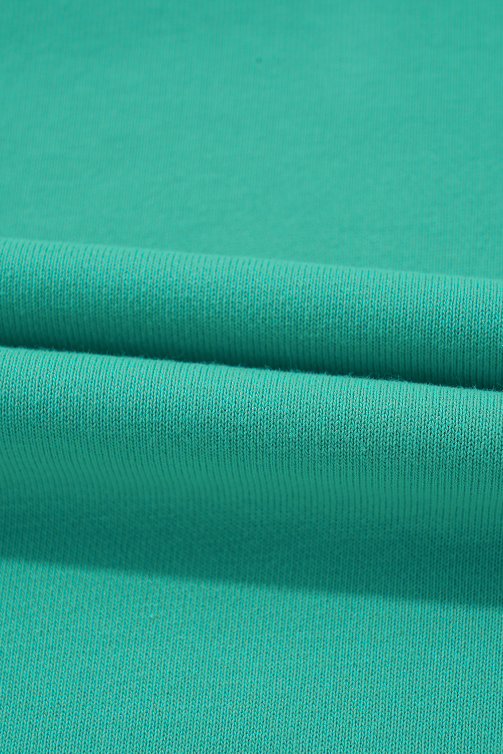 Close-up of teal green fabric texture for Malibu Marina top showcasing quality material and vibrant color.