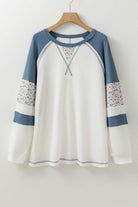 Boho floral waffle knit raglan top in cream and blue, featuring exposed seams and patchwork design for a chic, casual look.