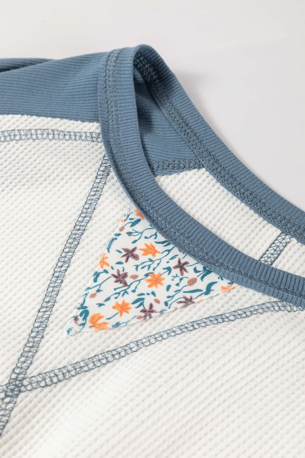 Close-up of the Serene Skies Top featuring floral patchwork design and textured waffle knit fabric.