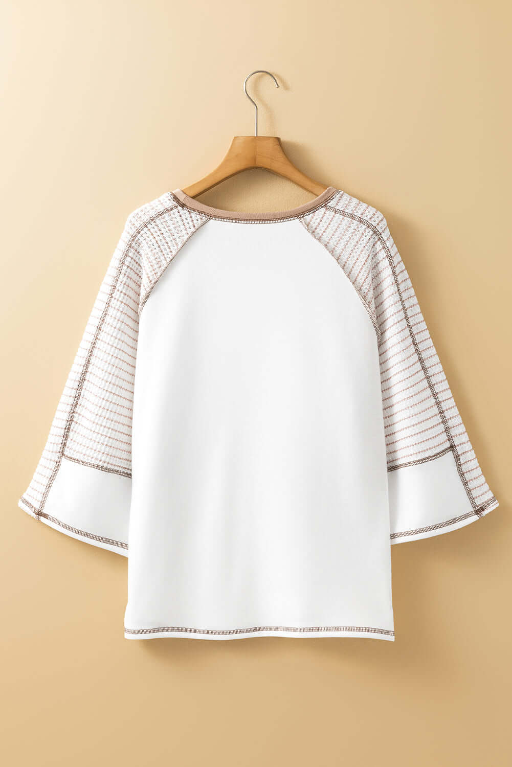 Back view of A Fine Line Top with patchwork design and striped raglan sleeves in white and tan.