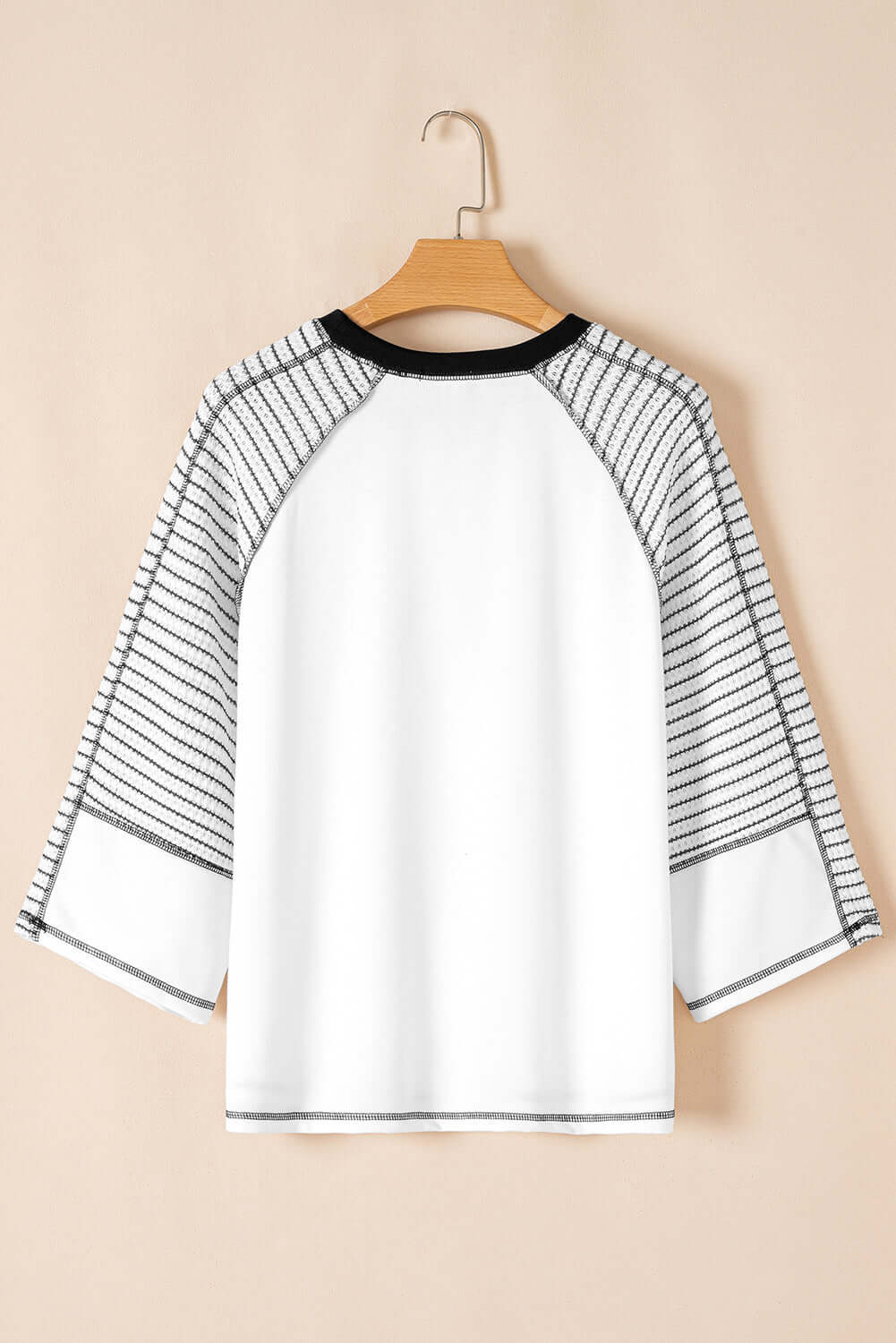 Back view of A Fine Line Top featuring patchwork design and striped raglan sleeves in white and black.